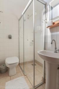 a bathroom with a toilet and a glass shower at Hotel Princeton in Piracicaba