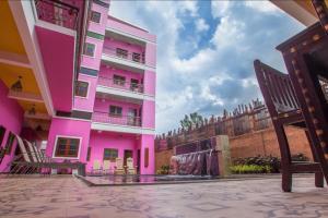 ein rosafarbenes Gebäude mit einer Bank davor in der Unterkunft Changpuak Boutique House in Chiang Mai