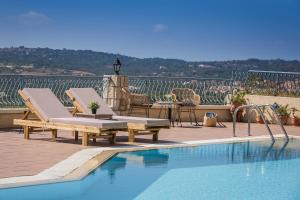 a swimming pool with two chaise lounges next to at Diana Suites in Trapezaki