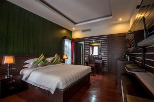 a bedroom with a bed with a green wall at De Sarann Villa in Siem Reap
