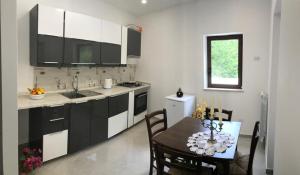 a kitchen with black and white cabinets and a table at VICO EQUENSE B&B 40 Steps in Vico Equense