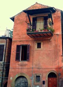 a red brick building with a balcony and a window at Alloggio turistico Porta Franceta in Sutri