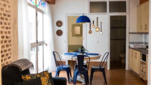 une cuisine avec une table et des chaises dans une pièce dans l'établissement Wallada Casa del Indiano, à Cordoue 23 autres photos