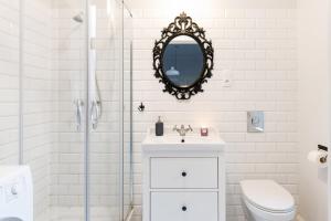 a white bathroom with a sink and a mirror at Apartament Nowe Miasto - przy Parku Róż in Gorzów Wielkopolski