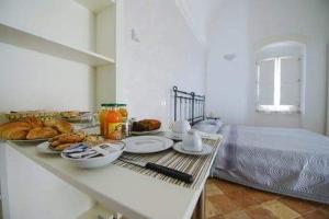 - une table avec de la nourriture dans une chambre avec un lit dans l'établissement B&B Il Palazzotto del Caveoso, à Matera