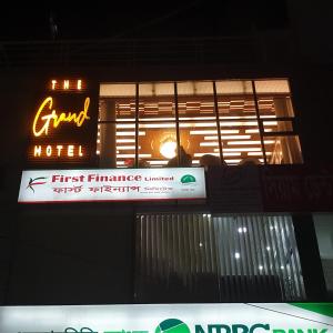 a neon sign hanging from the side of a building at The Grand Hotel BD in Sylhet