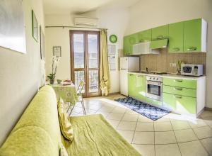 a kitchen with green cabinets and a table in it at South Sardinia Holidays in Domus de Maria