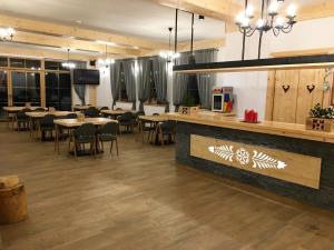 a restaurant with tables and chairs and a bar at Rezydencja Kojsowka in Witów