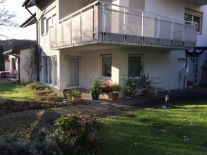 ein weißes Haus mit einem Balkon und Topfpflanzen in der Unterkunft Ferienwohnung Madeleine in Donzdorf