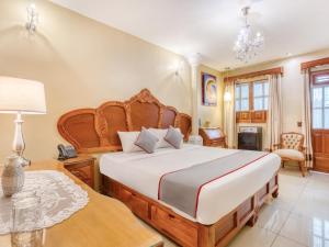 - une chambre avec un grand lit et une table dans l'établissement Hotel Boutique Casa Garay, à Oaxaca