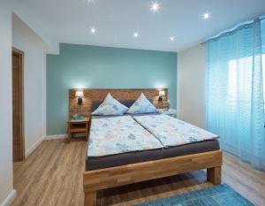 ein Schlafzimmer mit einem großen Bett mit blauen Wänden in der Unterkunft Landhaus Bad Bertrich in Bad Bertrich