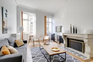 a living room with a couch and a fireplace at Le Palais Gallien in Bordeaux