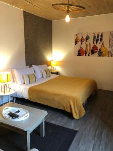 - une chambre avec un grand lit et une table dans l'établissement Une Chambre en Ville, à Saintes