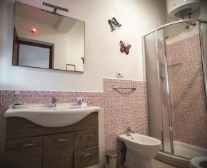 W łazience znajduje się umywalka, toaleta i lustro. w obiekcie Pinus Village Apartments 2 w Puli