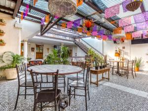 Habitación con mesa, sillas y plantas. en Hotel Boutique Casa Garay, en Oaxaca City