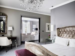 a bedroom with a bed and a chandelier at Queen Victoria Hotel by NEWMARK in Cape Town