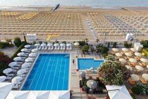 z powietrznego widoku na basen i plażę na terenie ośrodka w obiekcie Hotel Sirenetta w mieście Lido di Jesolo