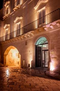 
a large stone building with a clock on it at Palazzo Gattini Luxury Hotel in Matera
