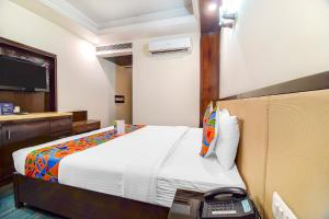 um quarto de hotel com uma cama e um telefone em FabHotel Marble Arch em Nova Deli