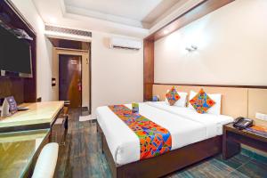 Habitación de hotel con cama y escritorio en FabHotel Marble Arch en Nueva Delhi