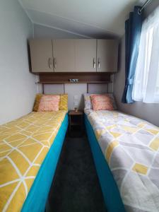 two beds sitting next to each other in a room at RJ Luxury Caravan Hire With Hot Tub in Tattershall +28 photos