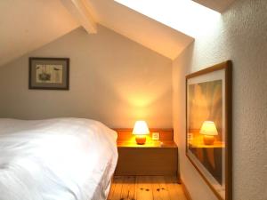 ein Schlafzimmer mit einem Bett und zwei Lampen an Nachttischen in der Unterkunft Eichenhof III in Grothusenkoog