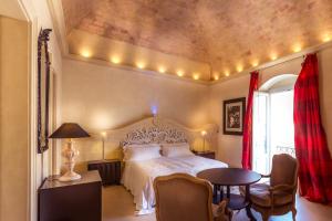 
a hotel room with a large bed and two lamps at Palazzo Gattini Luxury Hotel in Matera
