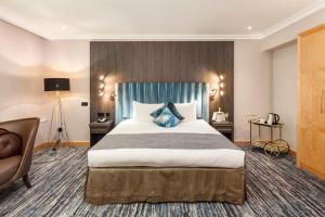 una habitación de hotel con una cama grande y una silla en Courthouse Hotel London, en Londres