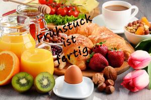 a breakfast table with breakfast foods and a sign that reads breakfast centre at Landhaus Bad Bertrich in Bad Bertrich