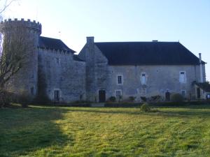 un vieux château avec une pelouse devant lui dans l'établissement La Mailholière, à Blanzay