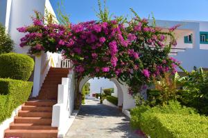 an archway with pink flowers on a white building at Mastichari Bay Hotel in Mastihari
