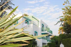 a white building with green and yellow accents at Mastichari Bay Hotel in Mastihari