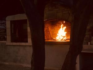 a brick oven with a fire in it at night at Holiday House Trovna in Pučišća