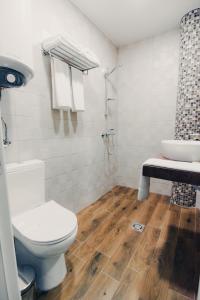 a bathroom with a toilet and a shower and a sink at Hotel Magura in Haskovo