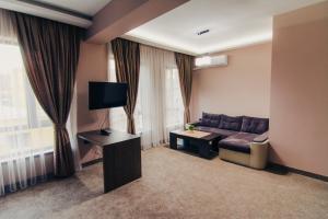 a living room with a couch and a tv at Hotel Magura in Haskovo