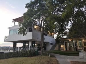 Norn Nab Dao RimPhu Resort في تشيانغ خان: بيت ابيض كبير فيه شجرة