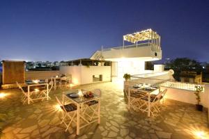 a rooftop patio with tables and chairs at night at Pink Elephant, Jaipur in Jaipur