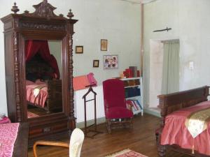 a bedroom with a large mirror and a red chair at La Mailholière in Blanzay