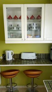 a kitchen counter with two stools and white cabinets at Chez marilyn in Deauville
