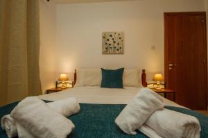 ein Schlafzimmer mit einem großen Bett mit Handtüchern darauf in der Unterkunft Ilioni Cottage by AgroHolidays in Kyperounta