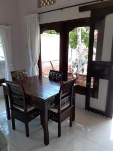 a wooden dining room table and chairs with a window at Double One Villas Amed II in Amed