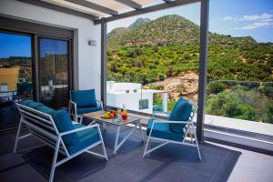 een kamer met een tafel en stoelen en uitzicht op de bergen bij Adrianna Villa 2 in Balíon