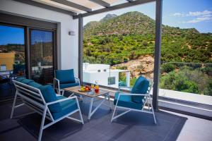 a room with a table and chairs and a mountain view at Adrianna Villa 2 in Balíon
