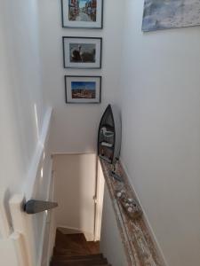a stairway with a rail and pictures on the wall at Romance en Baie de Somme in Saint-Valéry-sur-Somme