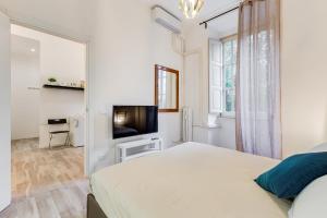 biała sypialnia z łóżkiem i telewizorem z płaskim ekranem w obiekcie BDC - Termini Sun Apartment w Rzymie
