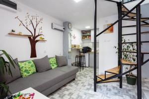 una sala de estar con sofá y un árbol en la pared en SB centar apartmani en Niš