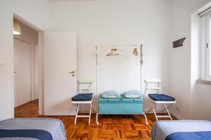 1 Schlafzimmer mit 2 Betten und 2 Stühlen in der Unterkunft Casa de Cascais do Pipas in Cascais