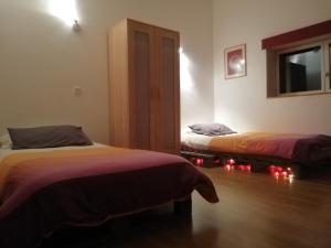a room with two beds and a window with red lights at La Maison Bleue23 in Sardent