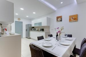 uma sala de jantar com mesa e cadeiras e uma cozinha em Luxury Apt w/ Side Seaviews and Pool, Top Location em Sliema