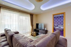 sala de estar con sofá grande y TV en Luxury Apt w/ Side Seaviews and Pool, Top Location en Sliema